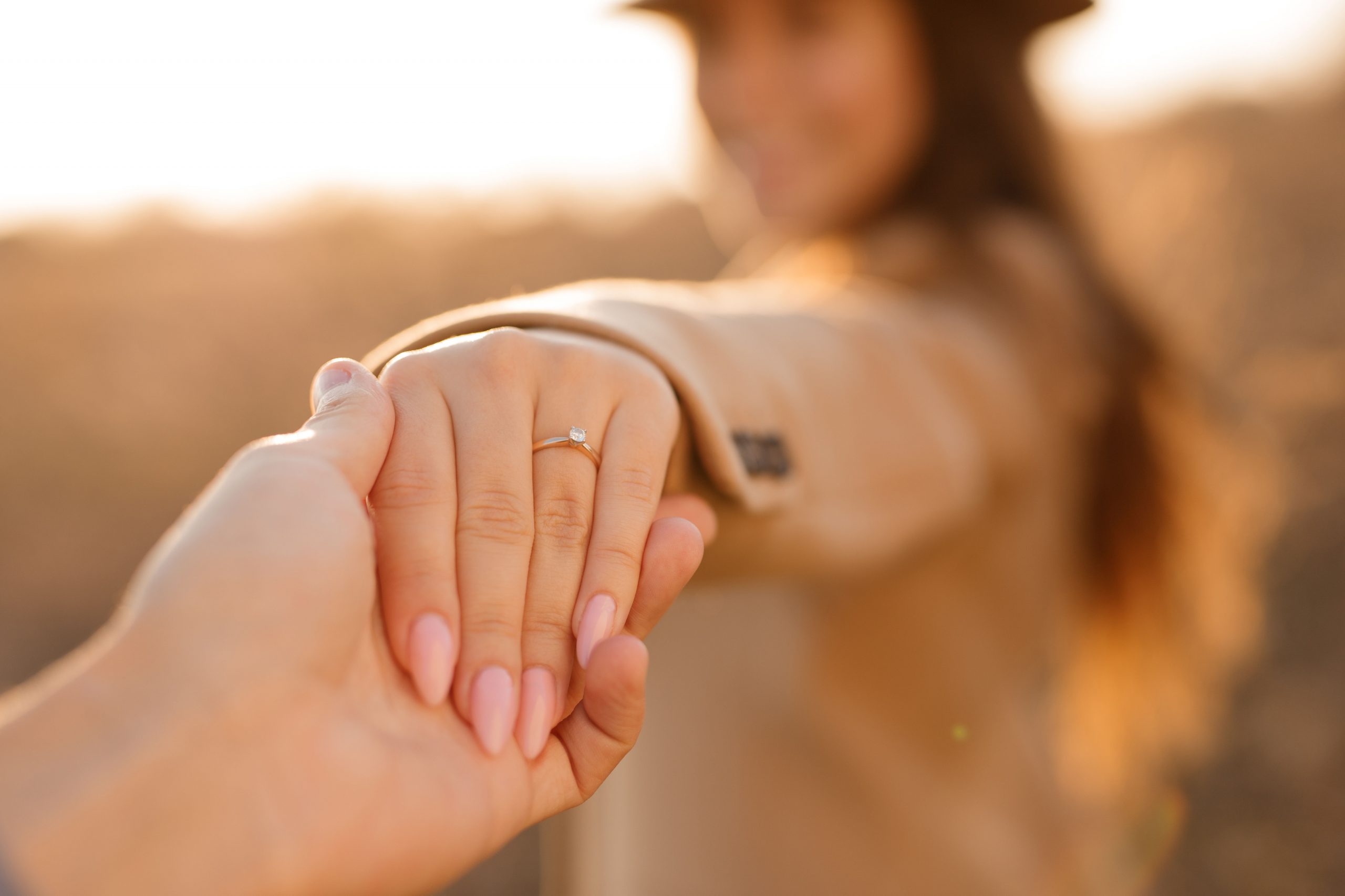 Lady holding her hand out with an engagement ring on her finger